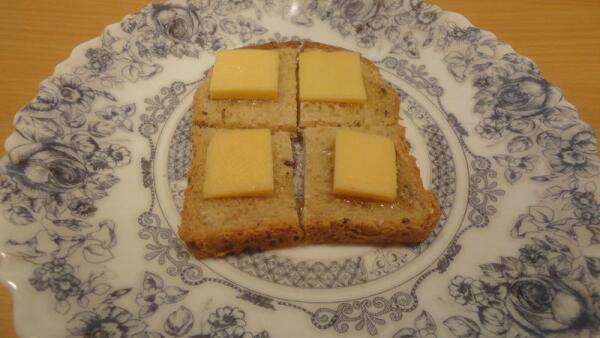 Режем кусочек хлеба на четыре части, каждую из которых присаливаем, чуть сбрызгиваем растительным маслом, сверху кладем тоненький ломтик твердого сыра