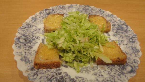 Выкладываем капусту на тарелку с прожаренными ломтиками хлеба