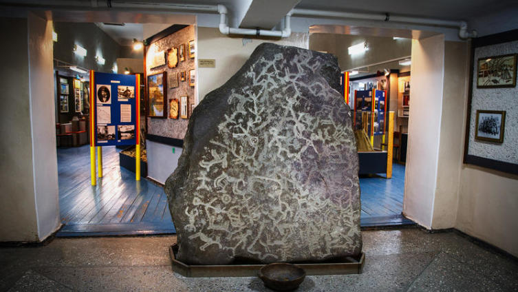 На входе в музей стоит камень с древними петроглифами