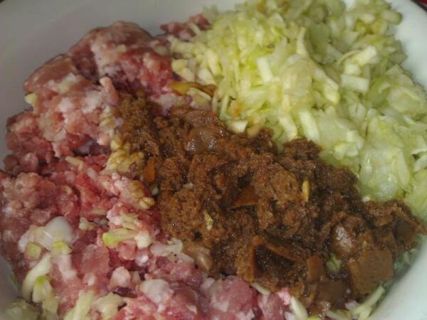 На мясорубке помолоть мясо, лук, кабачок, зелень и размоченный в соевом соусе батон