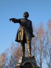 В отличие от правой, указующей, левая рука императора опущена. В ней он держит свиток