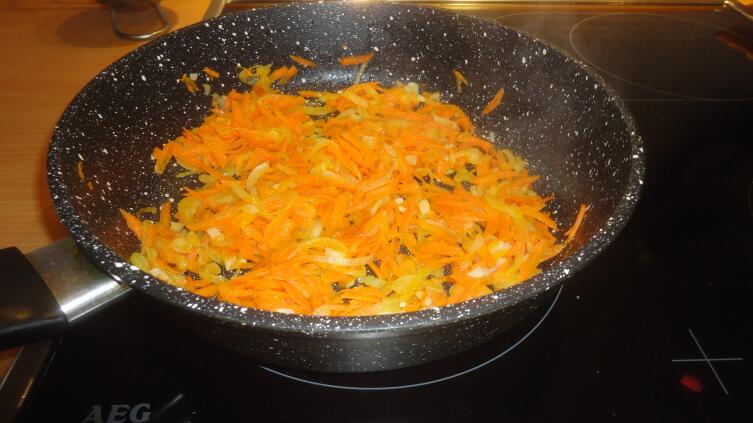 Минуты через две-три добавляем к луку морковь 