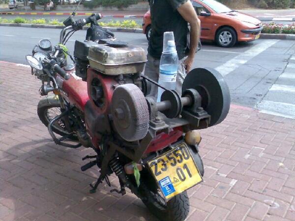 Современный уличный точильщик: на мотоцикле смонтирован небольшой бензиновый мотор, шпиндель с двумя кругами (один - шлифовальный, другой - абразивный)