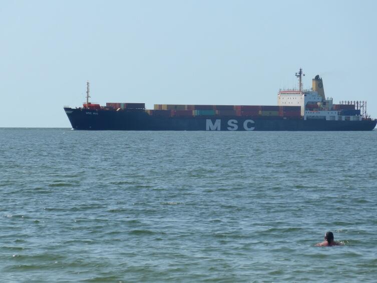 Контейнеровоз подходит ко входу в залив, снимок с берега Мельнраге Контейнеровоз подходит ко входу в залив, снимок с берега Мельнраге