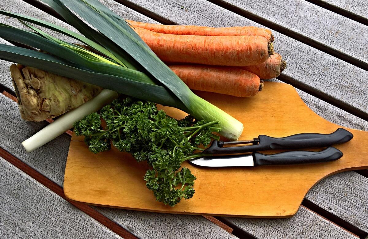 Овощи на столе. Морковь и сельдерей на столе. Специи. Нож.