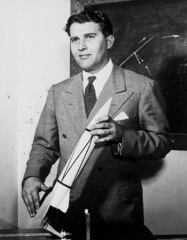 Вернер фон Браун держит в руках модель Фау-2