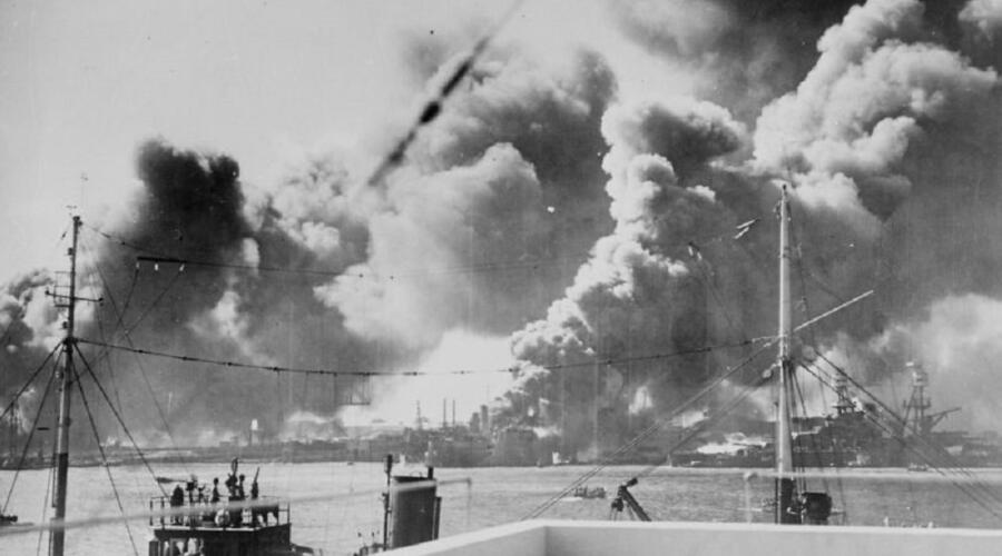 Вид на гавань Перл-Харбора с горящими американскими боевыми кораблями. В центре — эсминец «Шоу» (USS Shaw) горит после взрыва