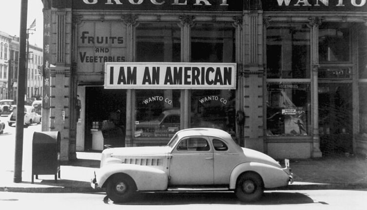 «Я американец». Американец японского происхождения вывесил этот плакат на следующий день после атаки на Пёрл-Харбор. Снимок был сделан в марте 1942 перед тем, как этого человека увезли в лагерь