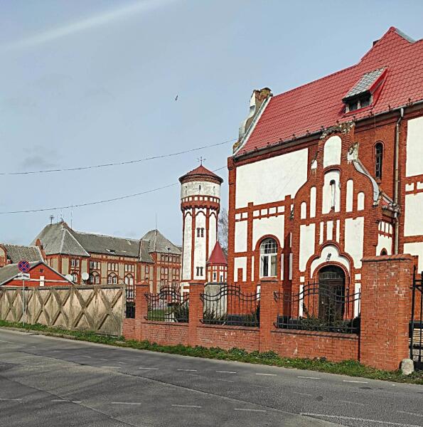 Комплекс зданий пехотных казарм Пиллау. Водонапорная башня. За ней — Северные казармы (их южный фасад). Справа (на переднем плане) — гостевой дом. Слева (за забором) — складские помещения. Вид с ул. Красной Армии (бывш. Гинденбургштрассе).