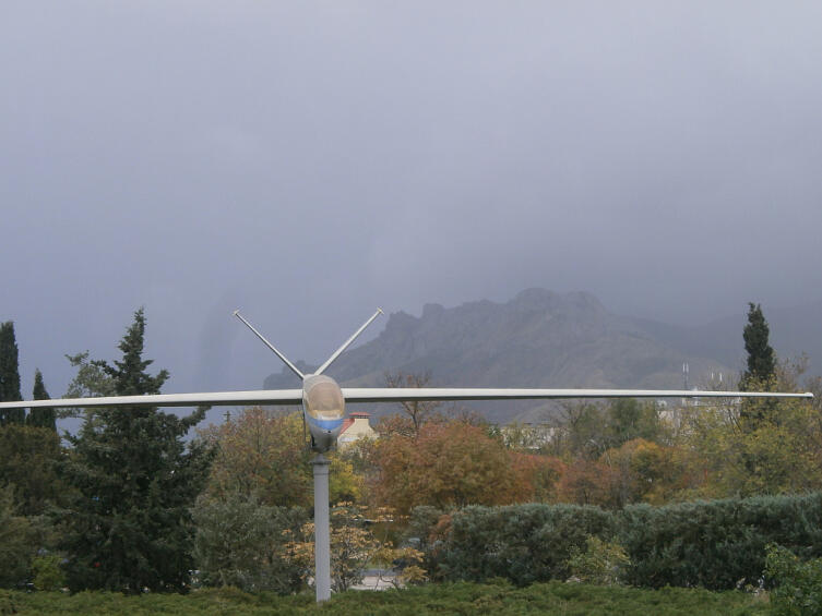 Памятник планеру на фоне туманного Карадага