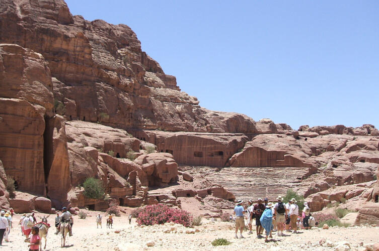 Туристы обозревают достопримечательности. Некоторые путешествуют на ослах