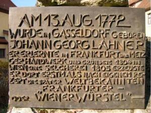 Бронзовая табличка с описанием истории сосисок на памятнике Ланеру